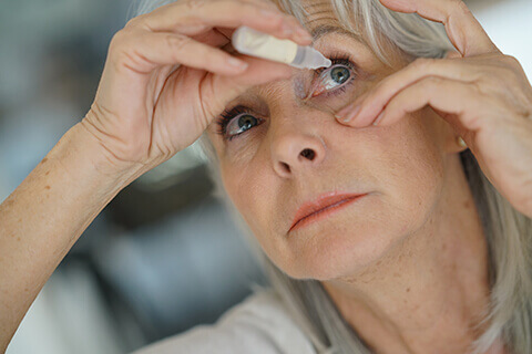 Older woman using eyedrops